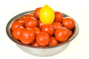 Tomatoes and lemon  in a bowl