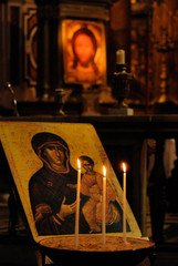 interior icons and burning candles in  orthodox temple