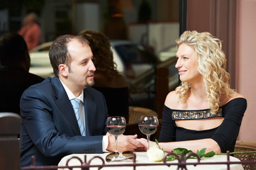 Man and girl with wine at cafe on a date