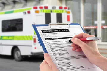 Hand Completing an Accident Report Form by Ambulance