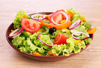 many vegetables on the plate on a wooden background