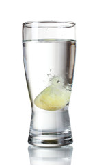 Glass with tablet in water with bubbles isolated on white