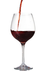 Red wine pouring into glass isolated on white