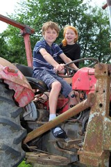 Zwei Kinder spielen auf einem alten Traktor