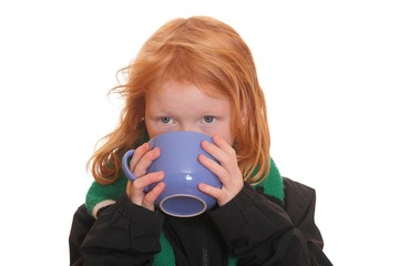Rothaariges Mädchen trinkt aus einem Becher Tee