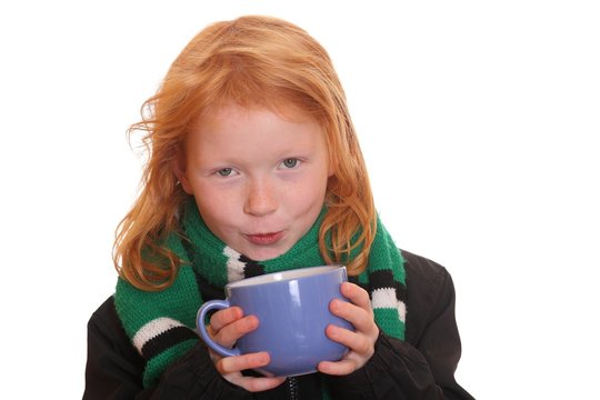 Rothaariges Mädchen trinkt aus einem Becher Tee