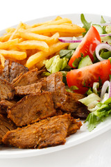 Grilled meat with French fries and vegetables