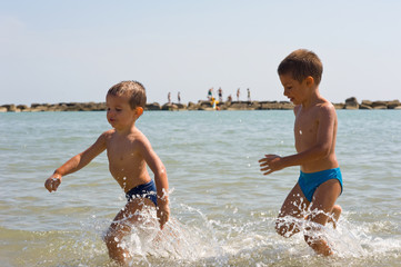 Two brothers playing on the beach.