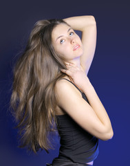 Naklejka premium The beautiful young woman on a dark background
