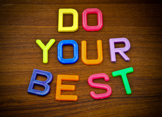 Do your best in colorful toy letters on wood background