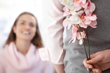 Young woman getting flowers from boyfriend