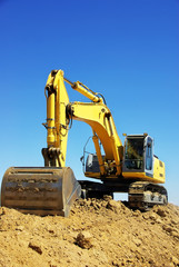 Yellow excavator on a working platform
