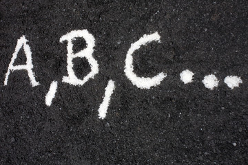 White letters a, b, c, written on the floor