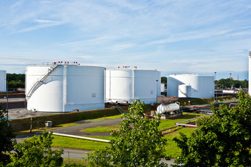 white tanks in tank farm with blue sky