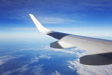 Fototapeta na wymiar Skrzydło samoloty pasażerskie, błękitne niebo i chmury.