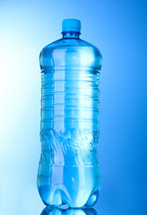Plastic bottle of water on blue background