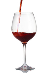 Red wine pouring into glass isolated on white