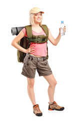 Woman hiker with backpack holding a bottle of water