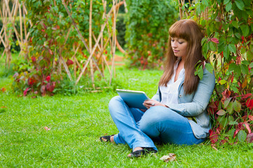 Young woman reading in tablet pc