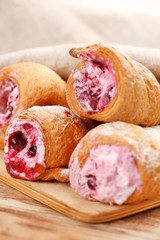 Cream-filled pastry roll on the wood board