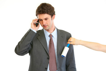 Naklejka premium Secretary cleaning chiefs suit while he talking on phone