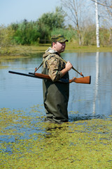hunter with rifle gun in bog