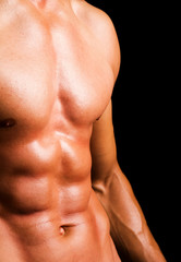 Man with naked muscled torso against black background