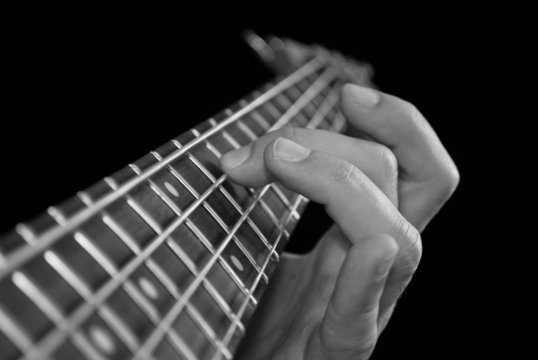 fingers on guitar fretboard