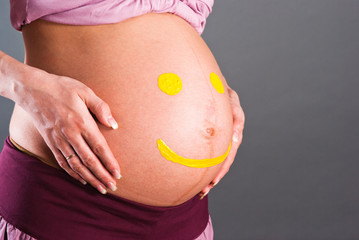 Yellow smilies on the abdomen of pregnant women