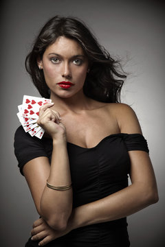 mujer atractiva jugando al poker con escalera de color