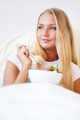 Obraz na płótnie Canvas Closeup portrait of a beautiful slender girl eating healthy food