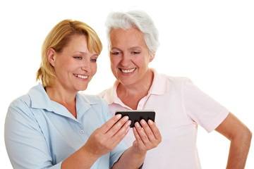 Seniorin schaut auf Smartphone