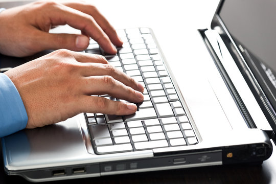 Male hands working on the laptop