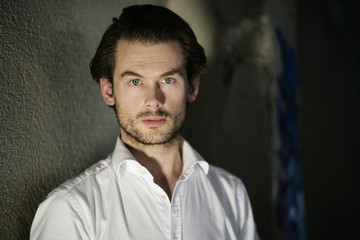 Fototapeta premium Mann im Hemd an der Wand