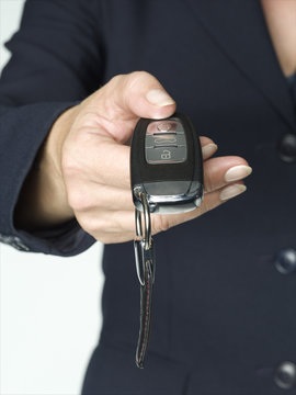Business woman handing over car key to customer