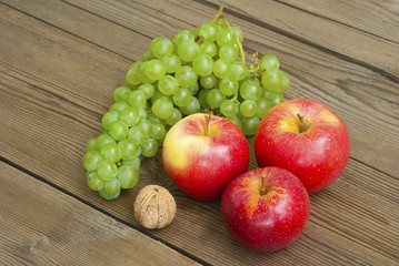 Naklejka na ściany i meble apples , nut and grapes on wooden table