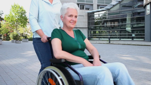 Nurse driving woman in wheelchair