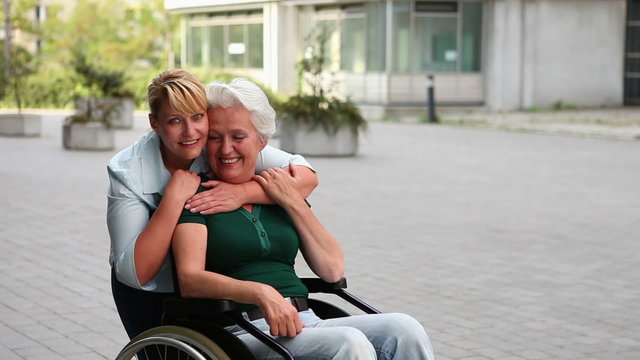 Woman in wheelchair and nurse holding thumbs up