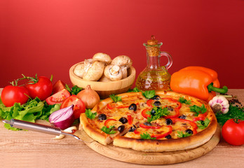 pizza and vegetables on a red background