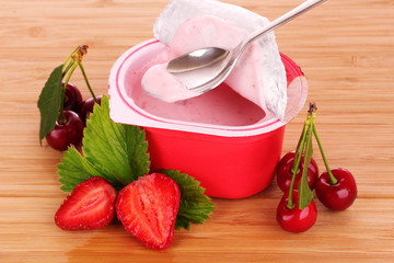 yogurt, cherries and strawberries on a wooden background