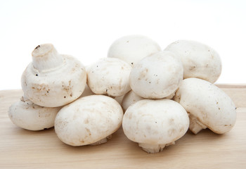 Champignon mushrooms on chopping board isolated on white