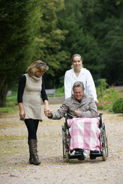Älteres Paar - Mann im Rollstuhl, mit Pflegekraft
