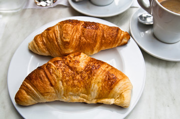 Breakfast with coffee and croissants on table