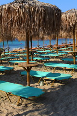 The beach near the blue sea with sun beds and umbrellas