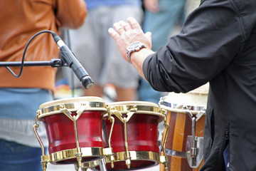Músico de una banda tocando percusión con sus manos - obrazy, fototapety, plakaty