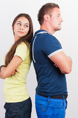 Portrait of a smiling young couple standing back to back on whit