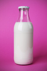 Bouteille de lait sur fond rose