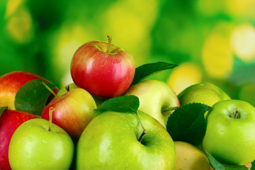 A lot of fresh organic apples on wooden table outside