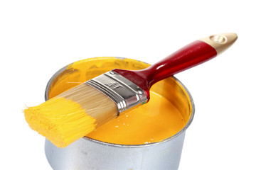 open can of yellow paint and brush isolated on white