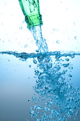 Green bottle and water splashing